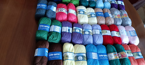 Filati per uncinetto. Diverse palline di lana multicolore di filo su sfondo  a righe rosa-azzurro a uncinetto. Concetto di hobby di ricci fatti a mano  da Foto stock - Alamy